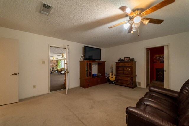 carpeted living room with a textured ceiling and ceiling fan