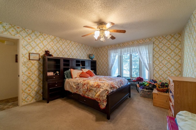 carpeted bedroom with ceiling fan and a textured ceiling