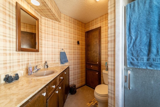 bathroom featuring vanity, toilet, and a textured ceiling