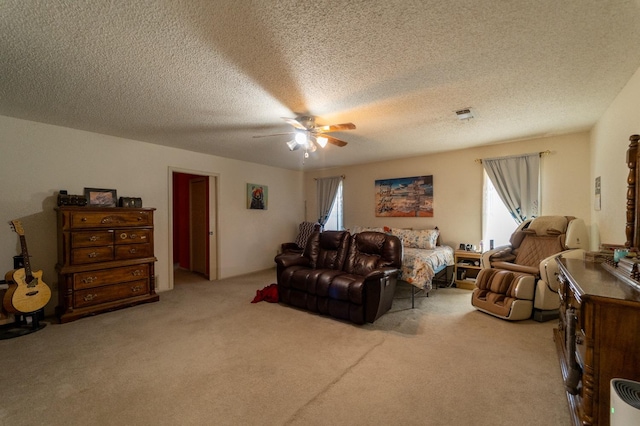 carpeted living room with ceiling fan and a textured ceiling