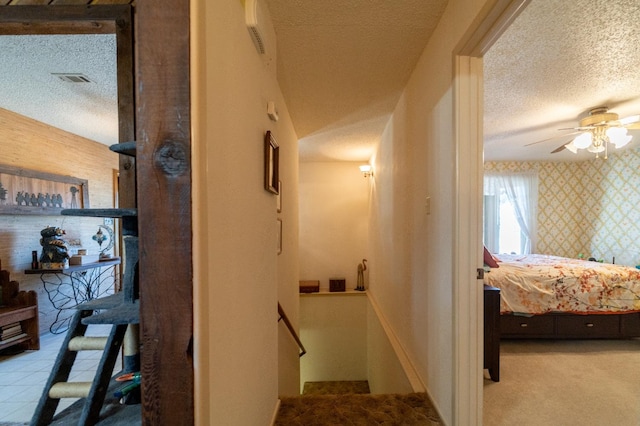 hallway featuring light carpet and a textured ceiling