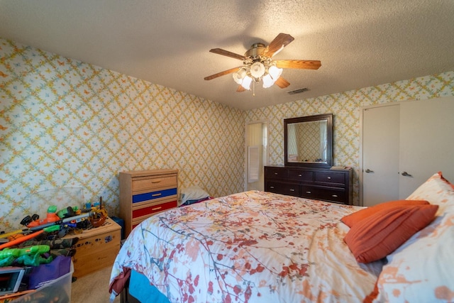 bedroom with ceiling fan and a textured ceiling