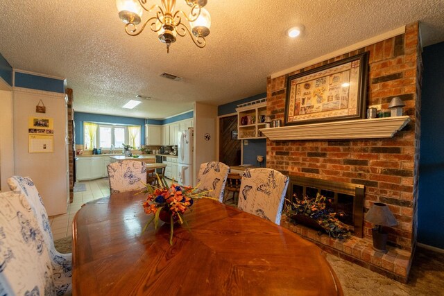 tiled dining room with a brick fireplace, a notable chandelier, and a textured ceiling