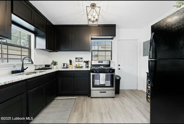 1502 30th St, Lubbock, TX 79411 - kitchen with gas range, freestanding refrigerator, light wood-type flooring, and light stone countertops