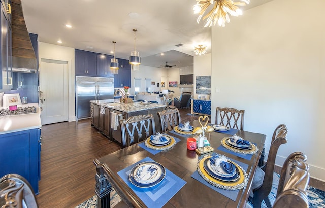 dining area featuring sink, dark hardwood / wood-style floors, and ceiling fan with notable chandelier