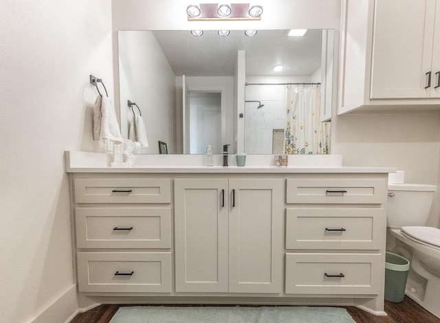 bathroom with hardwood / wood-style flooring, vanity, a shower with curtain, and toilet