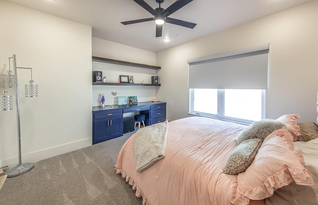 bedroom with ceiling fan, built in desk, and carpet