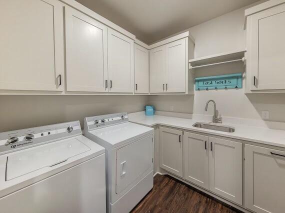 washroom with cabinets, sink, dark hardwood / wood-style flooring, and washer and clothes dryer