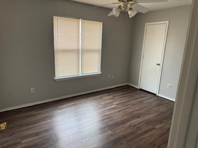 spare room with dark hardwood / wood-style floors and ceiling fan