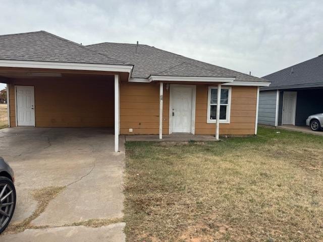 ranch-style house featuring a carport and a front lawn