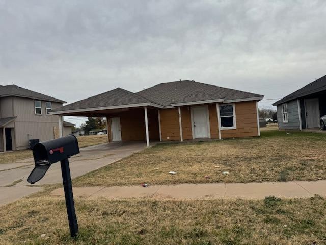 view of front of house featuring a carport and a front yard