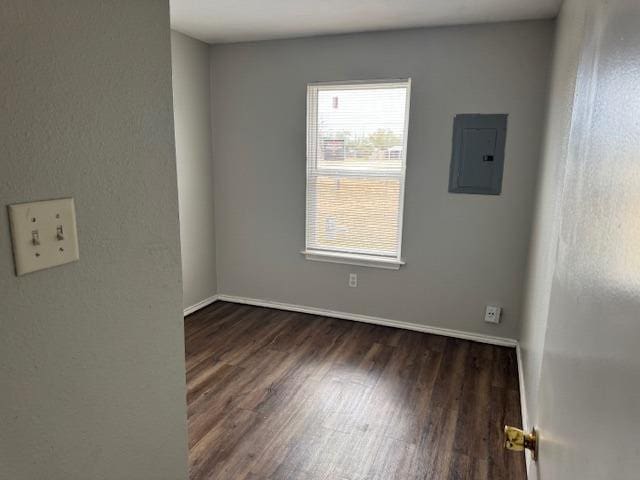 spare room featuring dark wood-type flooring and electric panel