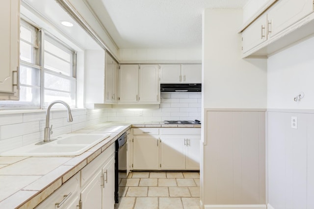 kitchen featuring sink, backsplash, black dishwasher, tile counters, and a textured ceiling