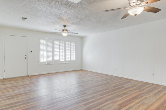 empty room featuring hardwood / wood-style floors, a textured ceiling, and ceiling fan