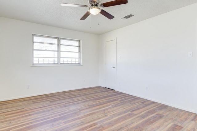 spare room featuring hardwood / wood-style flooring, ceiling fan, and a textured ceiling