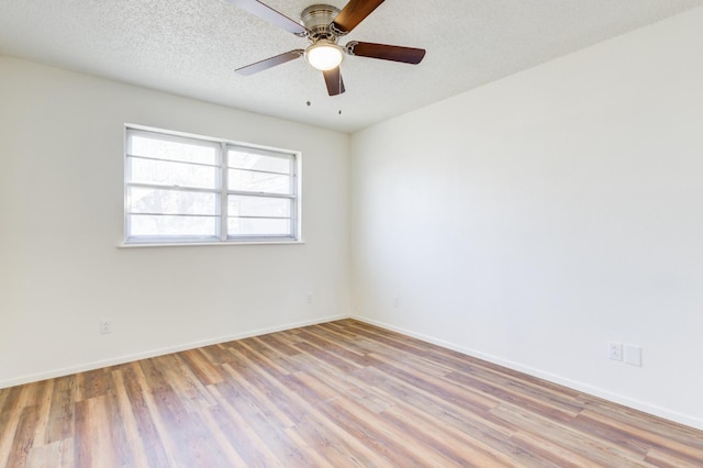 spare room featuring ceiling fan, light hardwood / wood-style flooring, and a textured ceiling