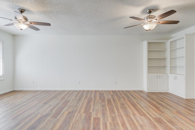 empty room with ceiling fan, hardwood / wood-style floors, and a textured ceiling