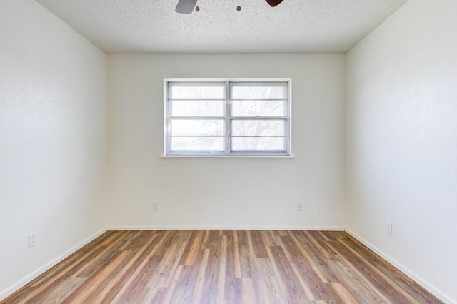 spare room with a textured ceiling, dark hardwood / wood-style floors, and ceiling fan