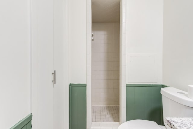 bathroom with tiled shower and toilet