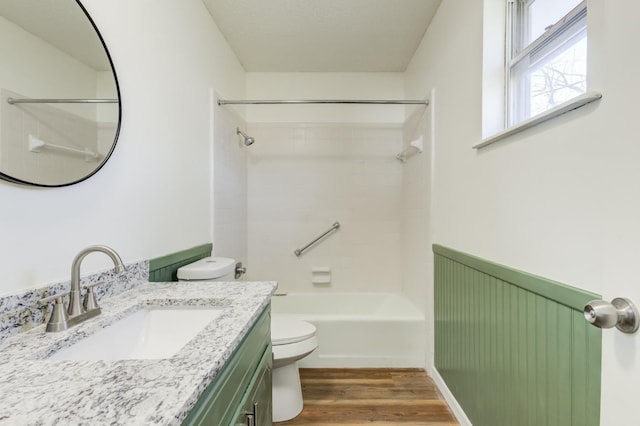 full bathroom featuring shower / tub combination, vanity, hardwood / wood-style floors, and toilet