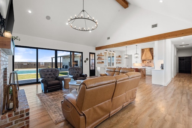 living room with a notable chandelier, beam ceiling, high vaulted ceiling, and light wood-type flooring