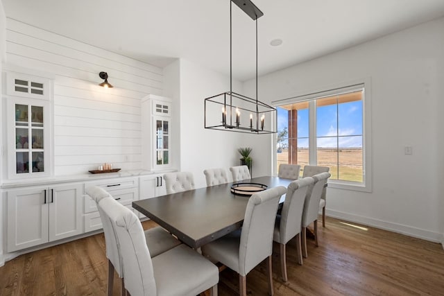 dining room featuring dark hardwood / wood-style flooring and an inviting chandelier