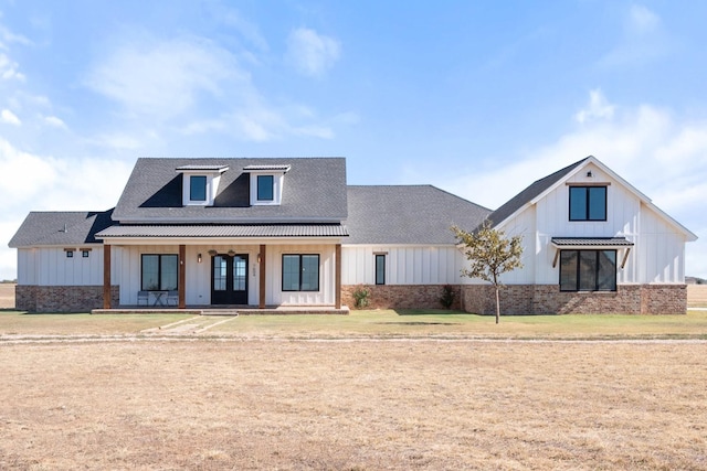 modern farmhouse featuring covered porch and a front lawn