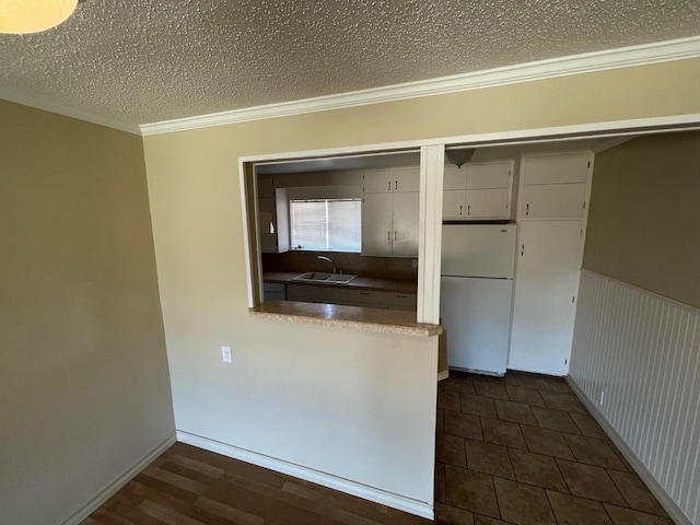 kitchen featuring sink, crown molding, a textured ceiling, and white fridge