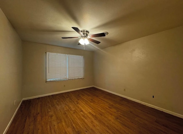 spare room with dark wood-type flooring and ceiling fan