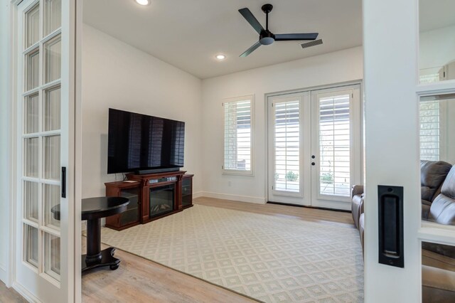 living room with hardwood / wood-style flooring, ceiling fan, and french doors