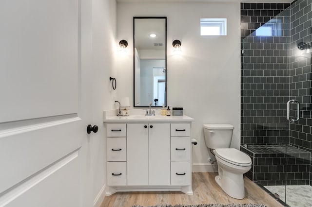 bathroom with vanity, an enclosed shower, hardwood / wood-style flooring, and toilet