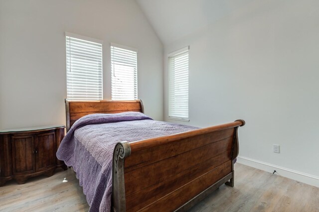 bedroom with lofted ceiling and light hardwood / wood-style floors