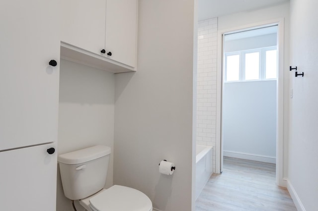 bathroom featuring wood-type flooring and toilet