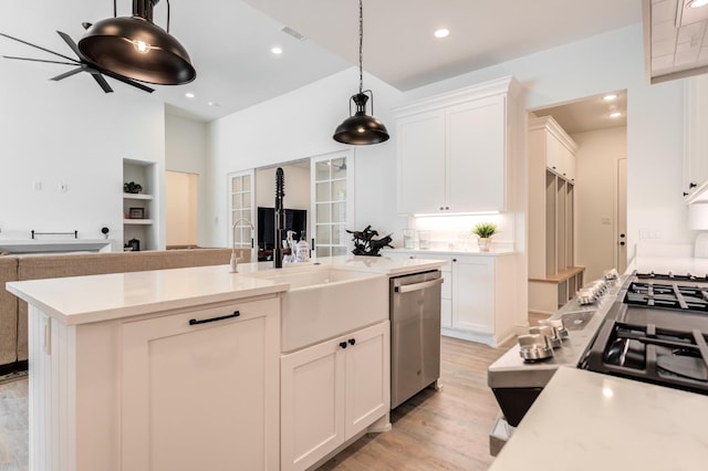 kitchen with pendant lighting, white cabinetry, a kitchen island with sink, and dishwasher