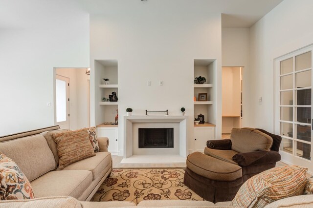 living room featuring a towering ceiling and built in features