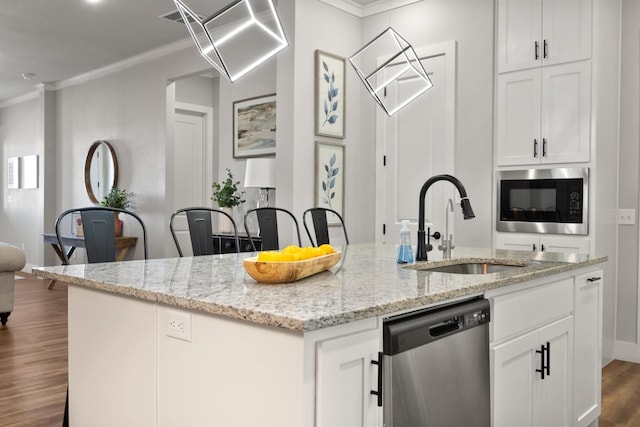 kitchen featuring sink, appliances with stainless steel finishes, white cabinetry, a kitchen island with sink, and light stone countertops