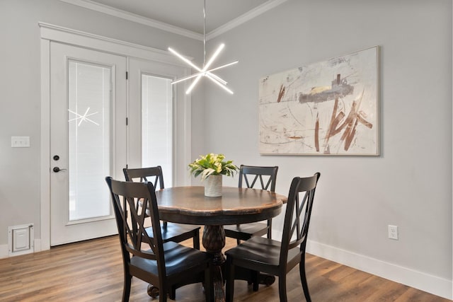 dining room with a notable chandelier, wood-type flooring, and ornamental molding