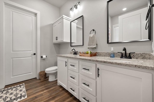 bathroom featuring vanity, wood-type flooring, and toilet