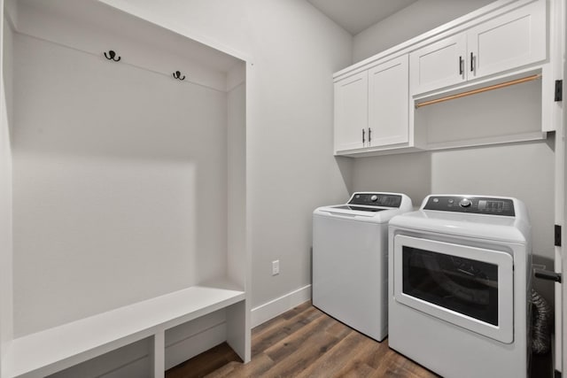 laundry room featuring dark wood-type flooring, cabinets, and washing machine and dryer