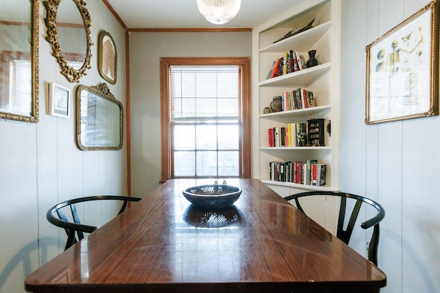 dining space featuring crown molding and built in features