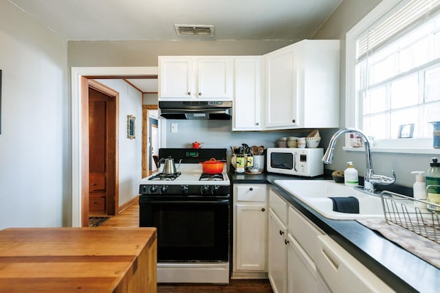 kitchen with sink, white cabinets, and white appliances