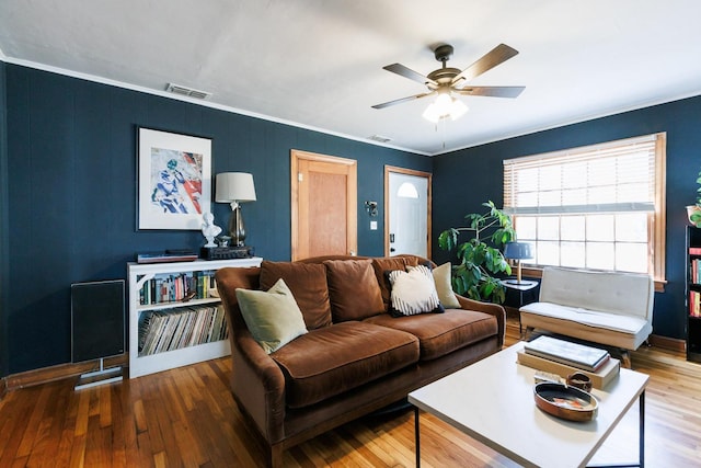 living room with hardwood / wood-style flooring, ornamental molding, and ceiling fan