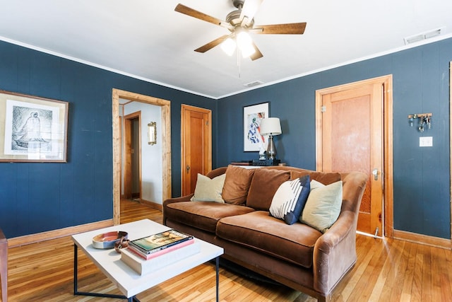 living room with ceiling fan, ornamental molding, and light hardwood / wood-style floors