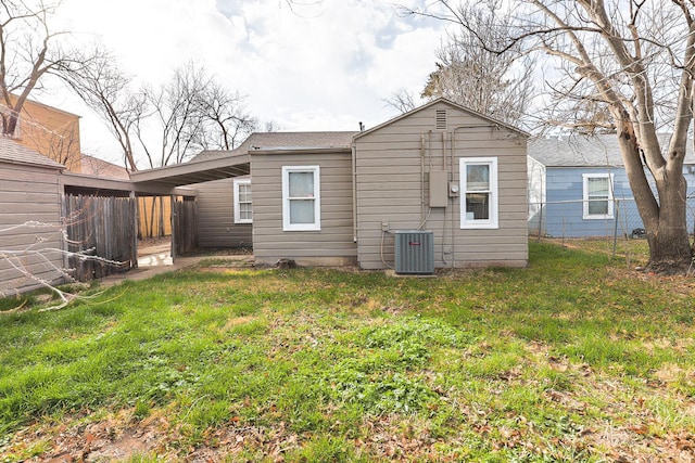 back of property with a yard and central air condition unit