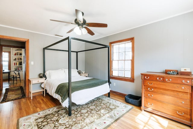 bedroom featuring hardwood / wood-style floors, crown molding, and ceiling fan