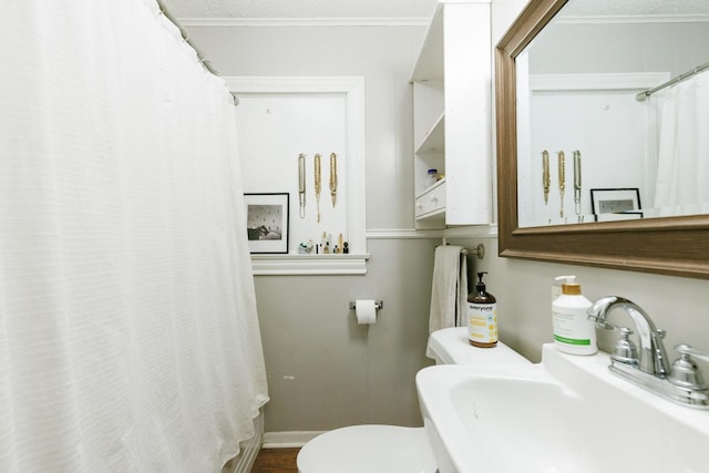 bathroom with crown molding, sink, a textured ceiling, and toilet