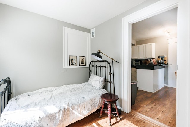 bedroom with dark hardwood / wood-style flooring