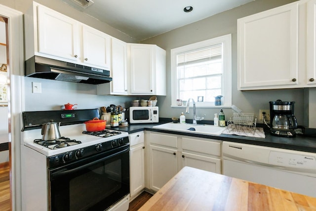 kitchen with sink, white appliances, wood-type flooring, and white cabinets