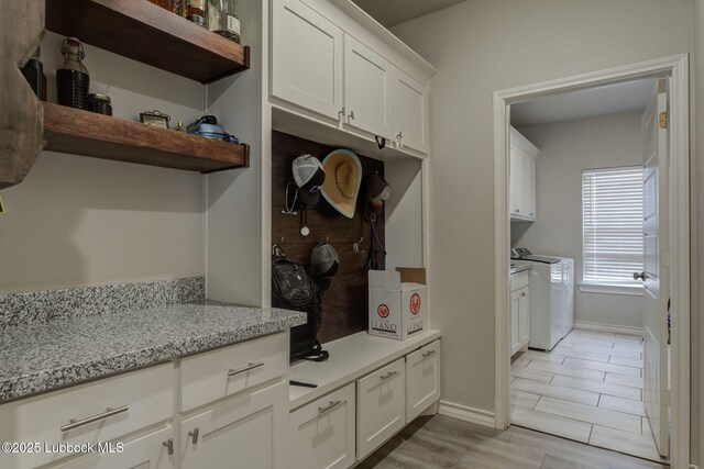 12010 N Crk 1500, Shallowater, TX 79363 - mudroom featuring washer and clothes dryer, baseboards, and light wood-style floors