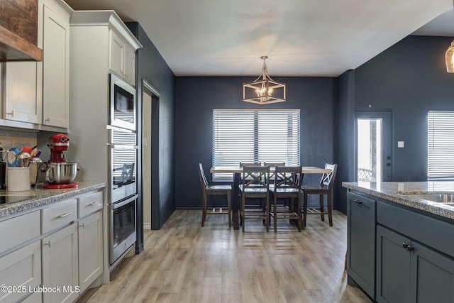 12010 N Crk 1500, Shallowater, TX 79363 - kitchen featuring stainless steel appliances, a chandelier, light wood-type flooring, and tasteful backsplash